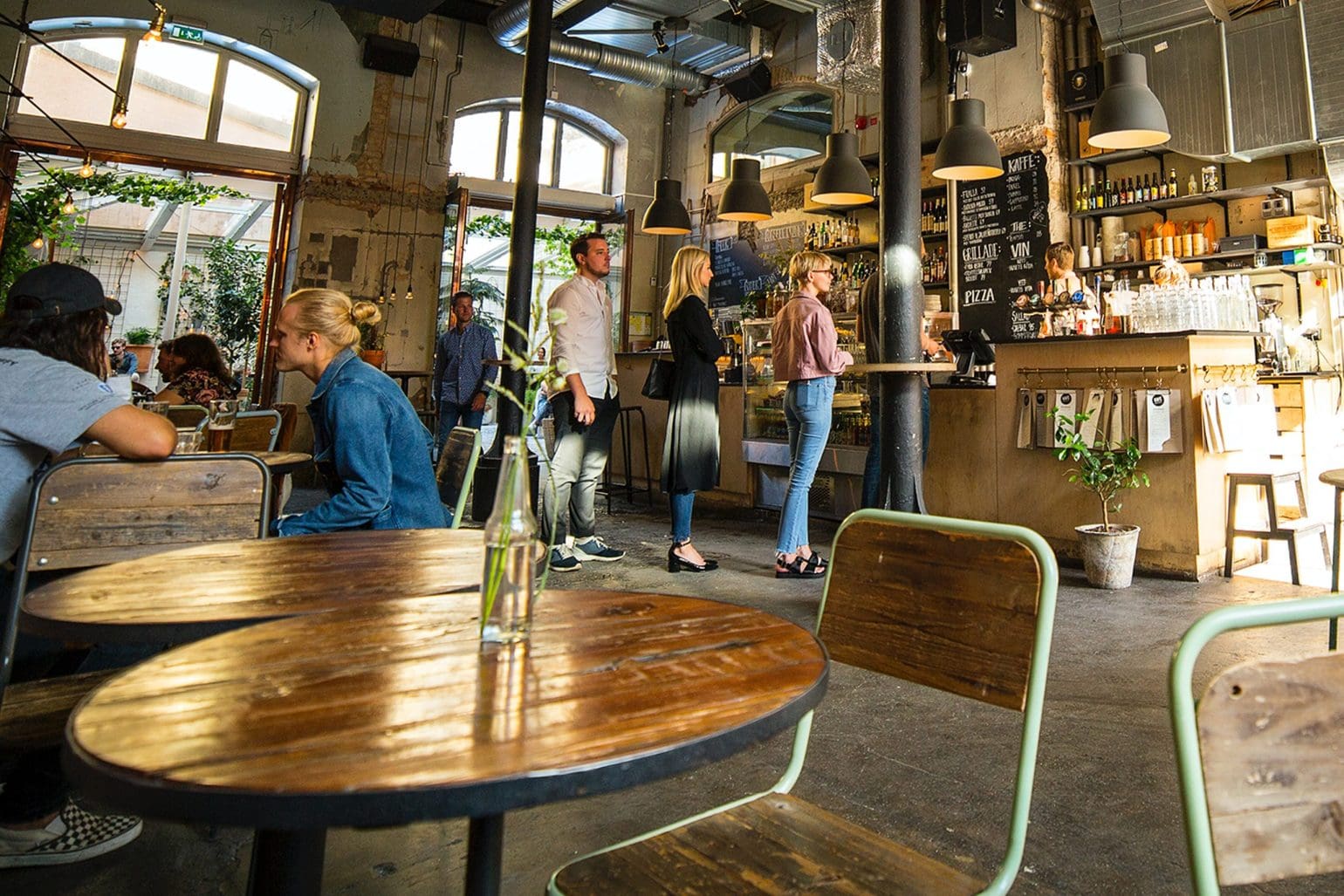 Bild eines Cafés, in dem einige Leute in einer Schlange stehen und andere sitzen und ihre Getränke genießen