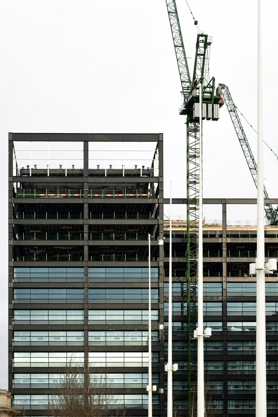 ein Kran neben einem halbfertigen Gebäude