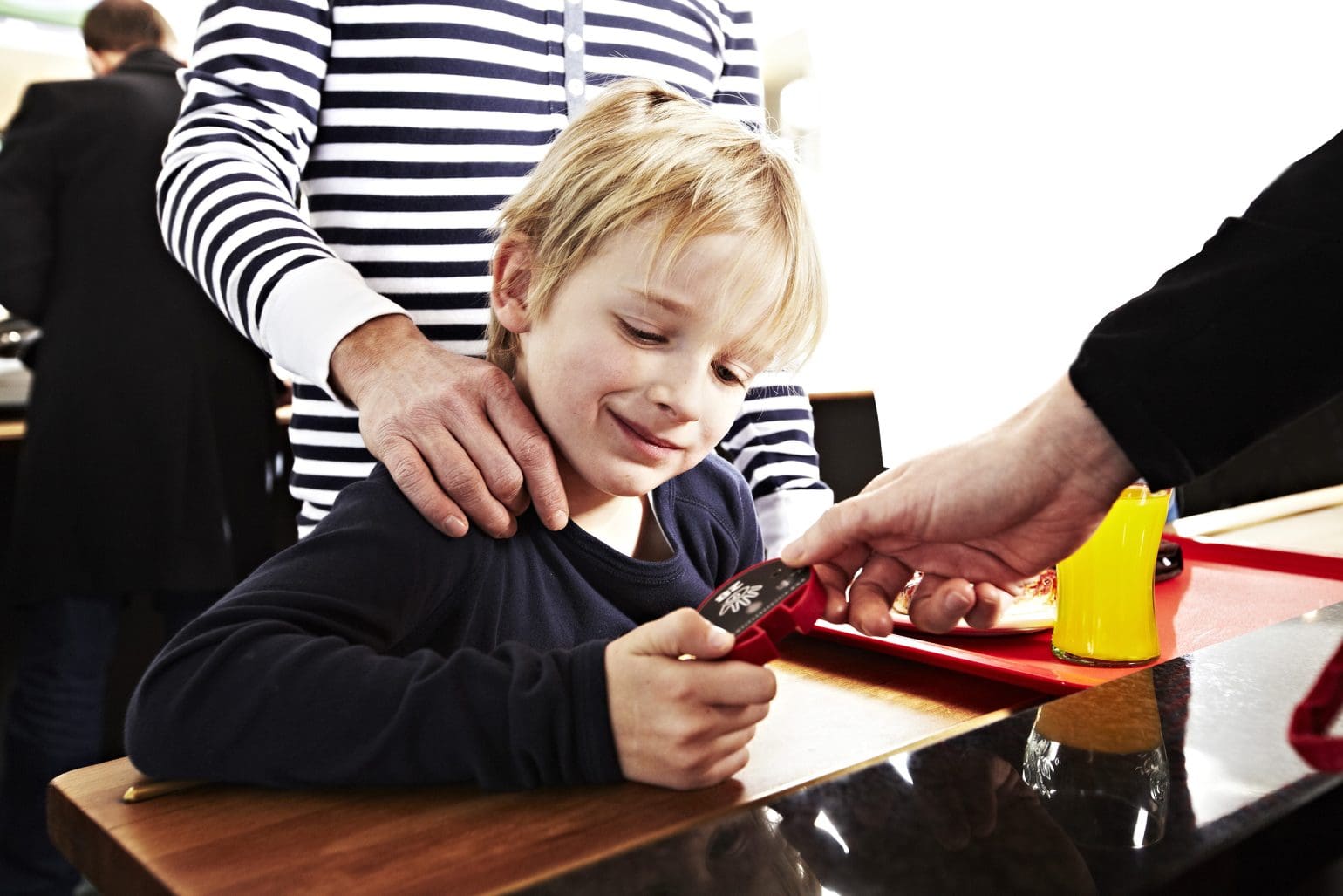 Dem kleinen Jungen wird ein stiller Bestellpager, ein Gästeruf, gezeigt.