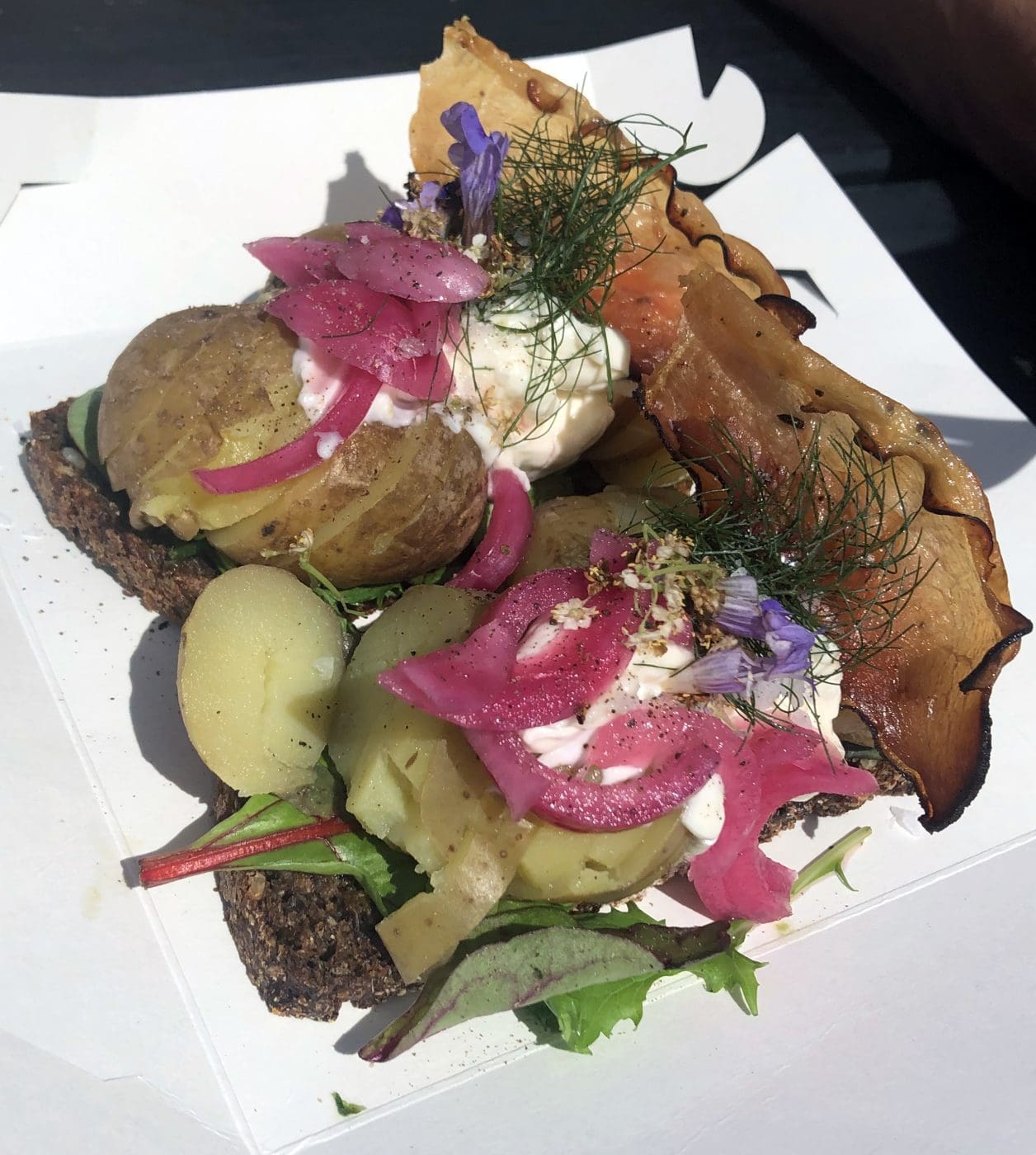 Bild eines Roggenbrotgerichts mit Kartoffeln, Salat und geräuchertem Speck.